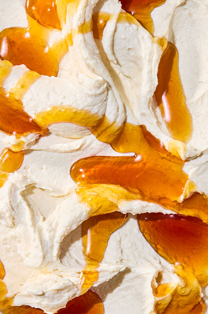 Detail photograph of creamy goat cheese with a drizzle of hot honey.