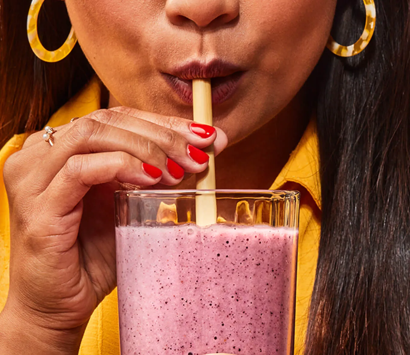 A person drinking a smoothie through a straw