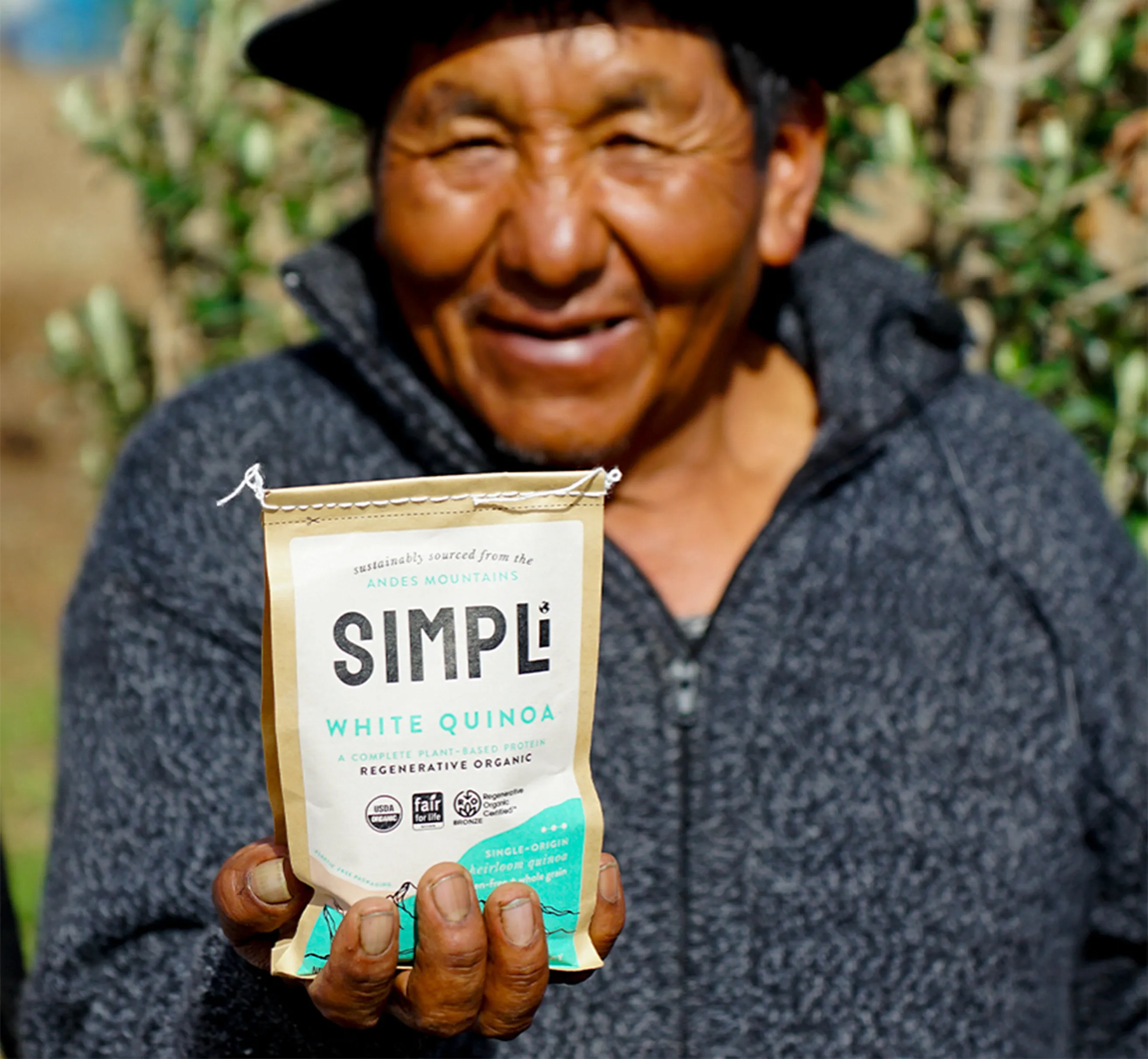 A person holding a bag of Simpli white quinoa
