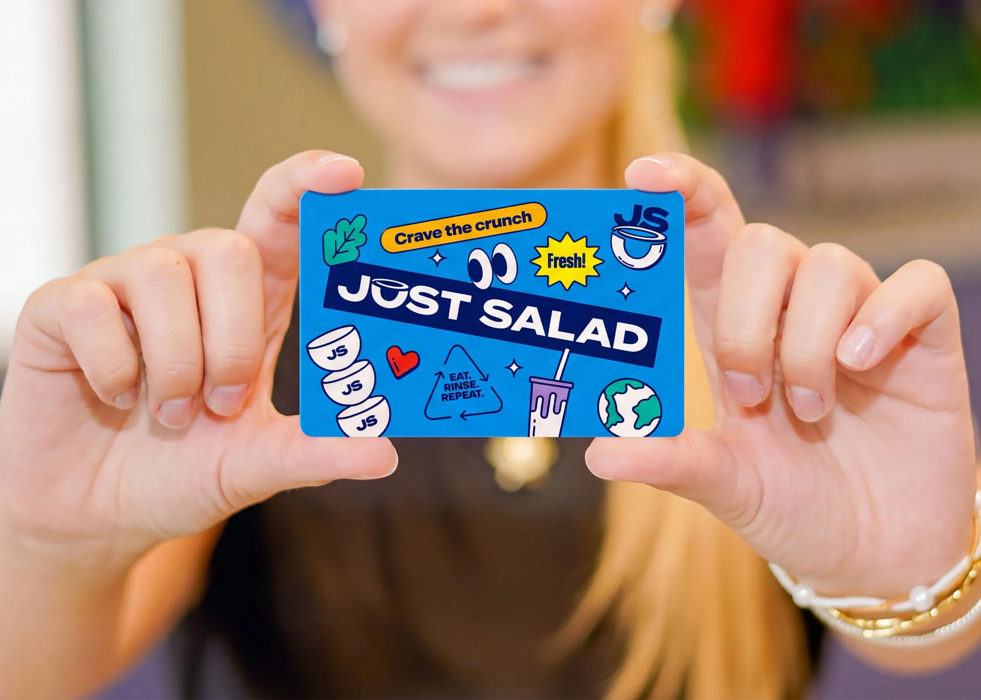 A person holding a blue Just Salad gift card