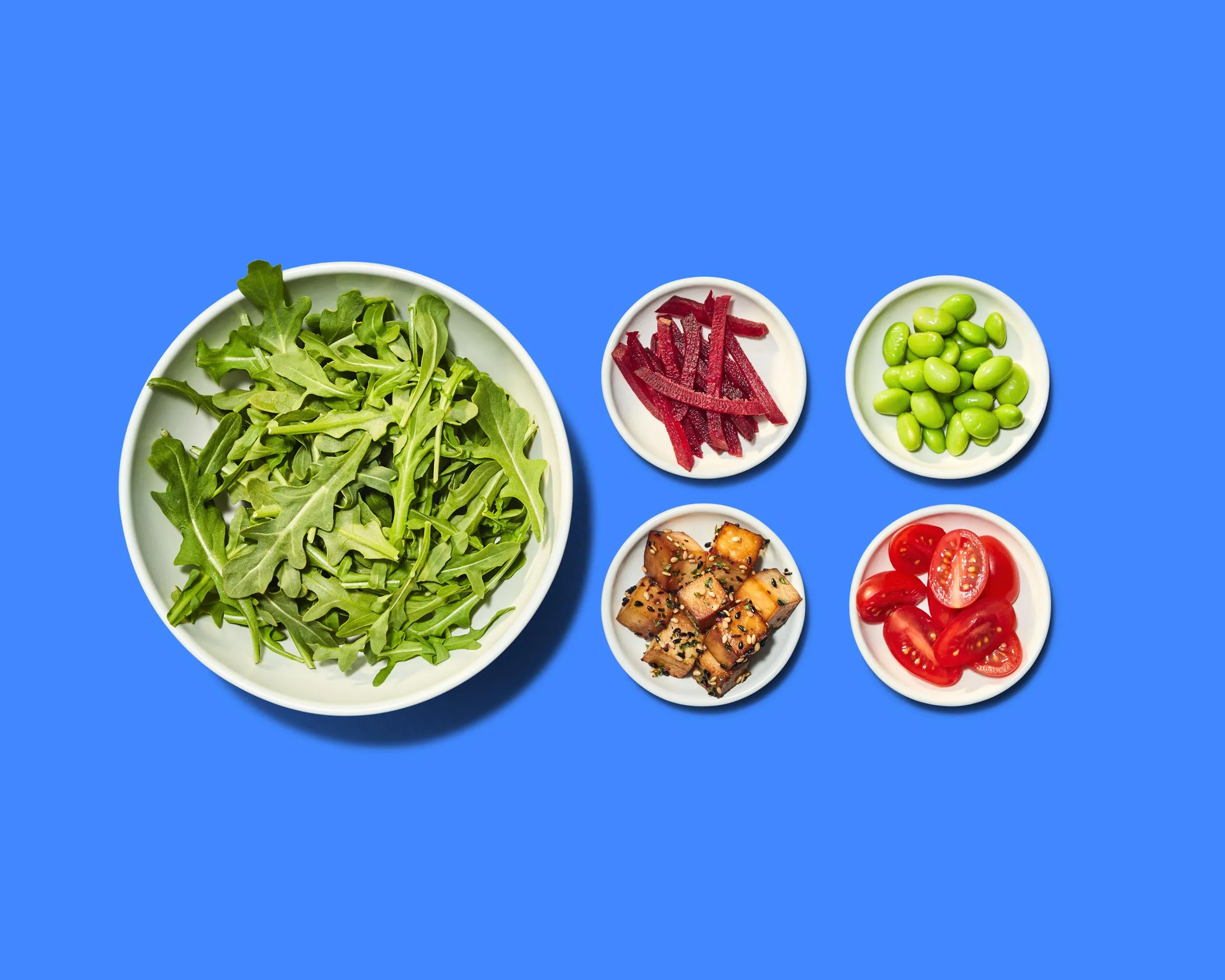 A deconstructed salad on a solid background