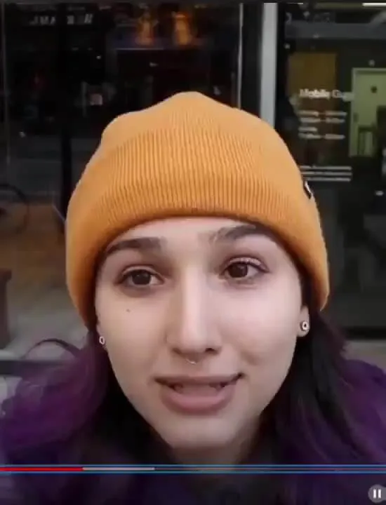 Woman wearing a hat recording a video